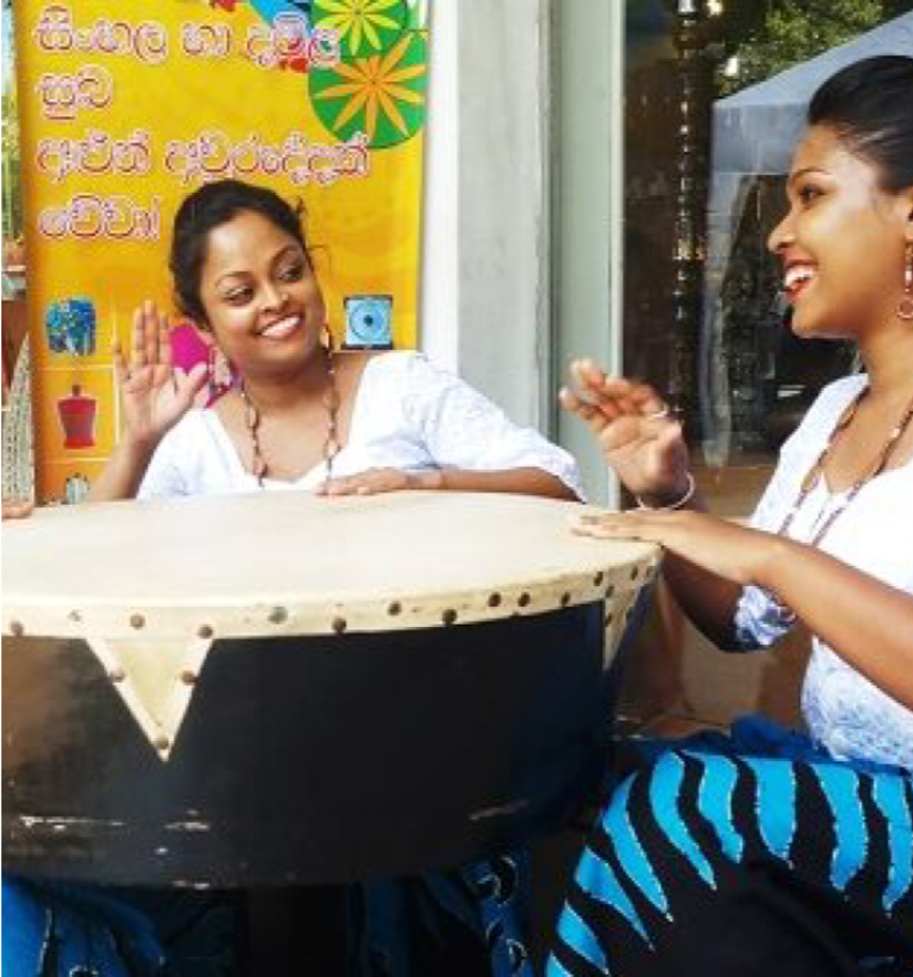 Two women playing drum