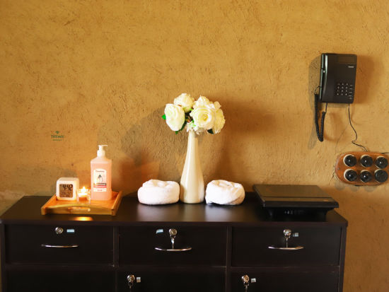 a closeup shot of a table decked with lotions and flowers at Themis Mudhouse - A Nature's Retreat Resort & Wellness