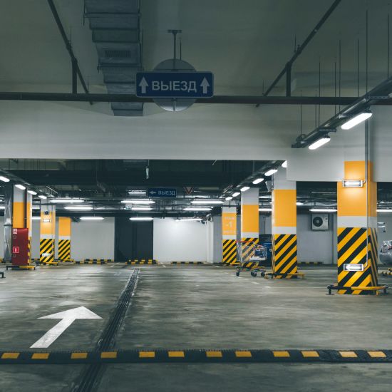 an empty parking lot in the basement of a building with bright coloured stickers on the pillars