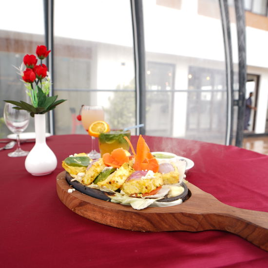 a food item served in a unique tray with roses kept in a small vase on the table