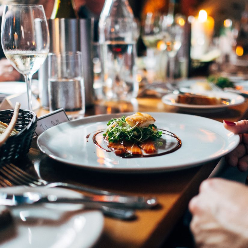 delectable dish on a plate with glasses on a table