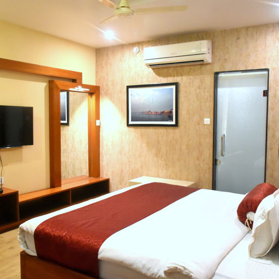 A sideview of bed in Presidential Suite with TV and A/C | Hotel City Inn, Varanasi