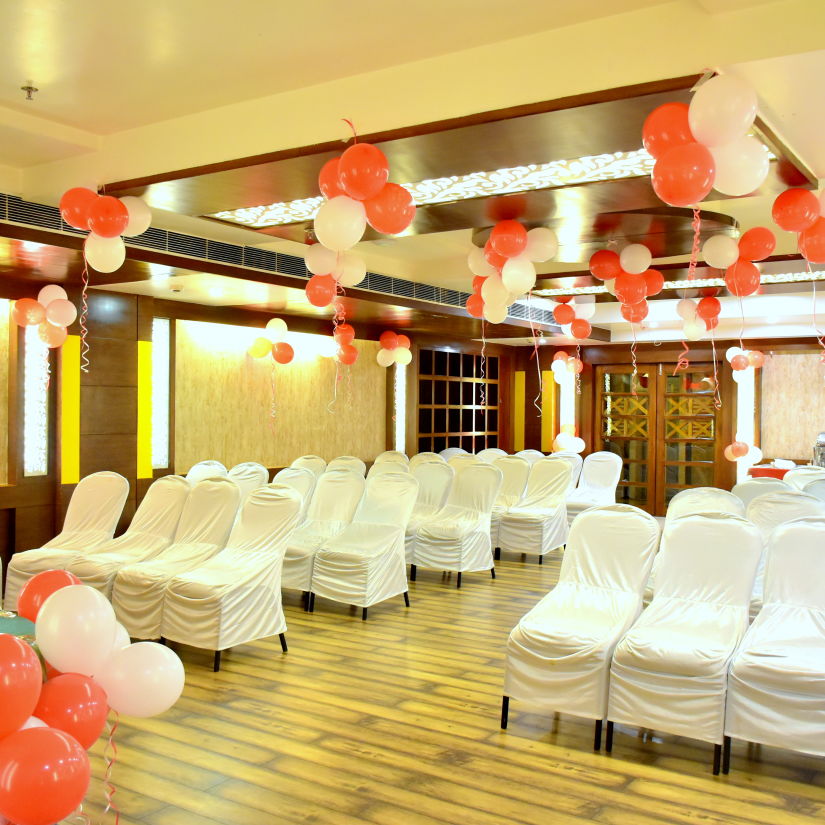 A front view of chairs placed in a banquet hall decorated with ballons | Hotel City Inn, Varanasi