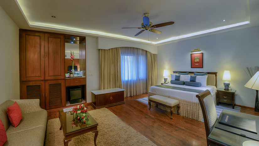 Clarks Varanasi - a sofa set facing the king size bed of the suite in Varanasi