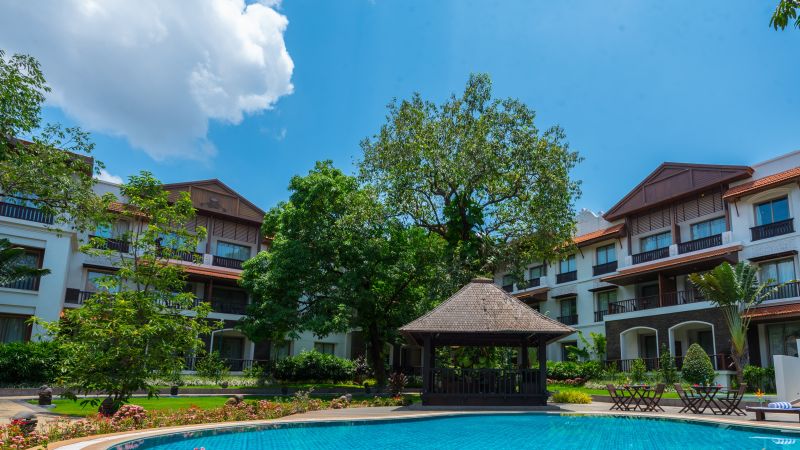 Swimming pool in front of a white resort building