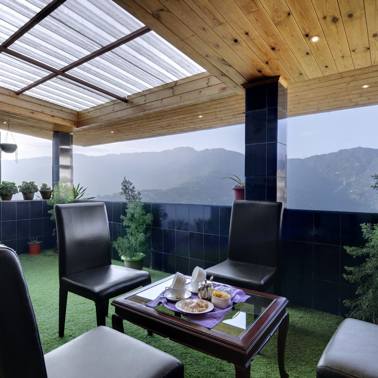 seating arrangements in an outdoor area with grass on the floor - Sumi Shangrila, Deorali