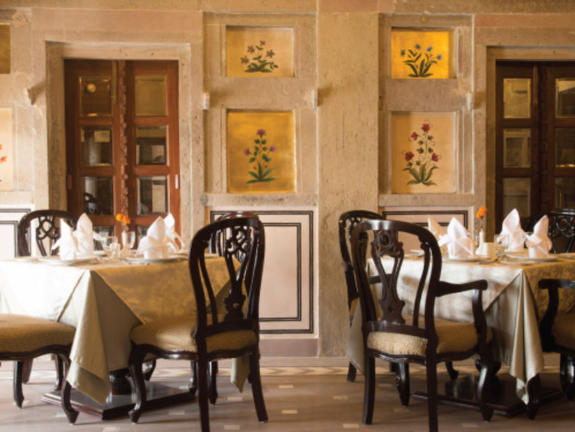 a dining hall decorated with wall paintings and seating options