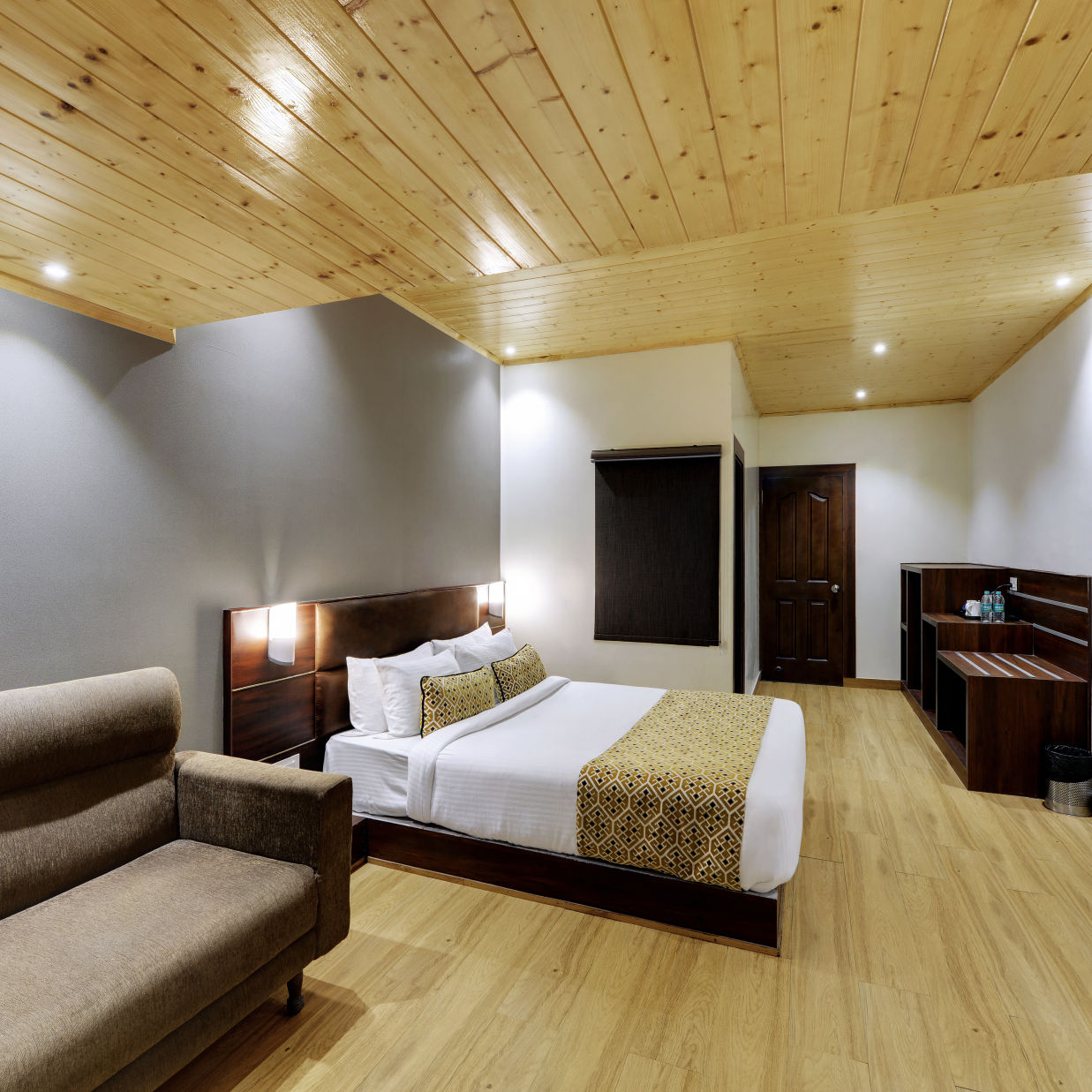 Side view of a double bed and a sofa in the Executive Deluxe Room at Hotel Sumi Vista T.V Tower