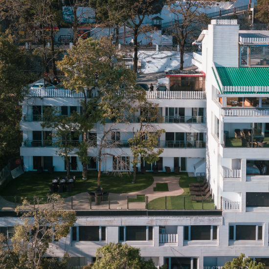 An aerial view of a building with trees around | Sumi Yash Shree Hotels & Resorts