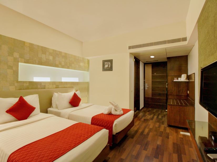 the twin beds facing the TV offered at the executive room - Monarch Luxur Hotel, Bangalore