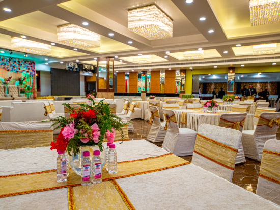 A wide view of a well-lit banquet hall with chairs and tables placed in it Sun Park Hotel & Banquet, Chandigarh - Zirakpur