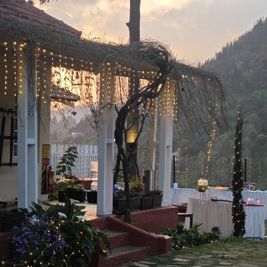 alt-text Outdoor wedding reception area at dusk with string lights and a covered porch in Coonoor.