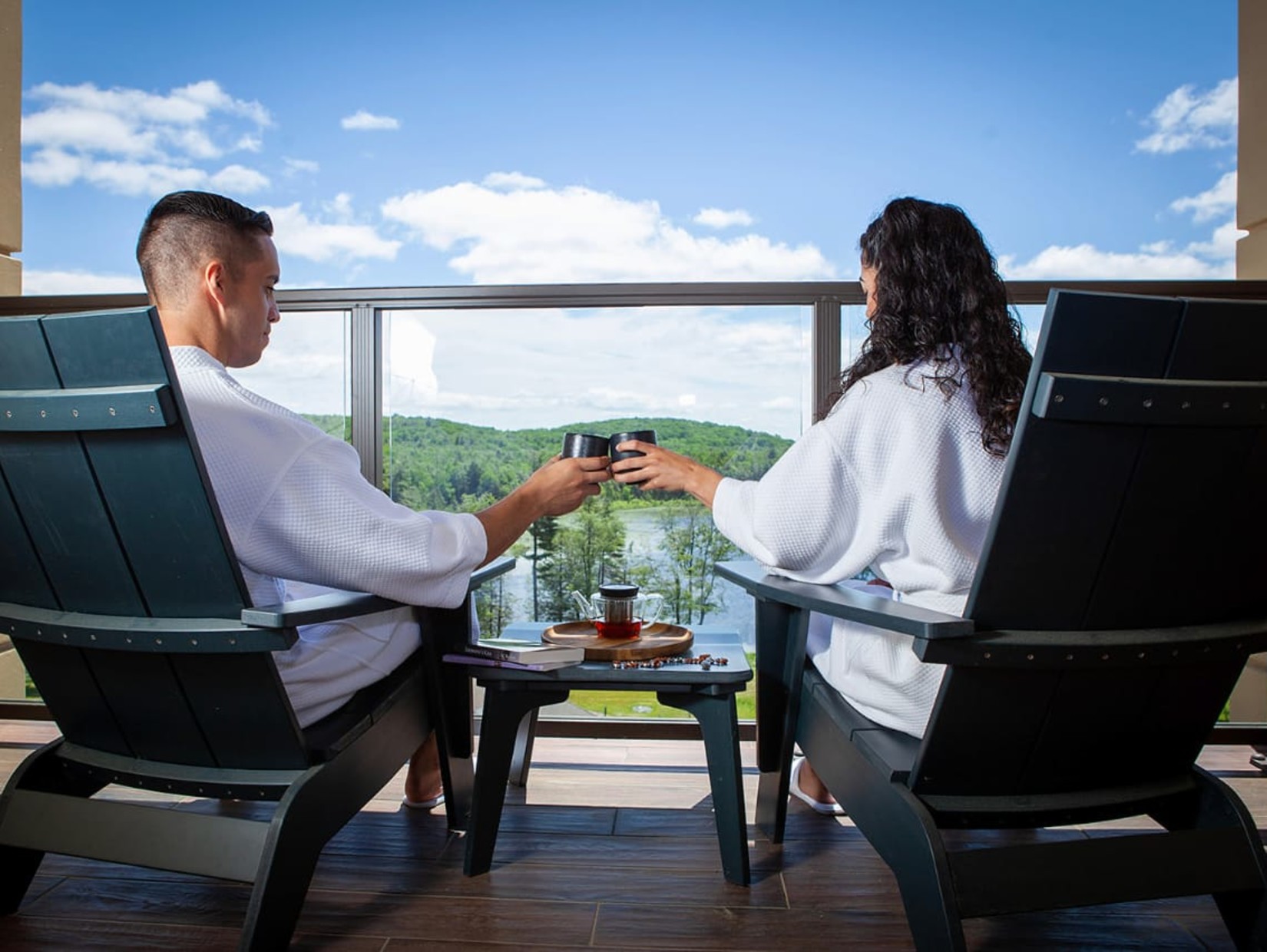 a couple sitting in bathrobes enjoying a view from the balcony