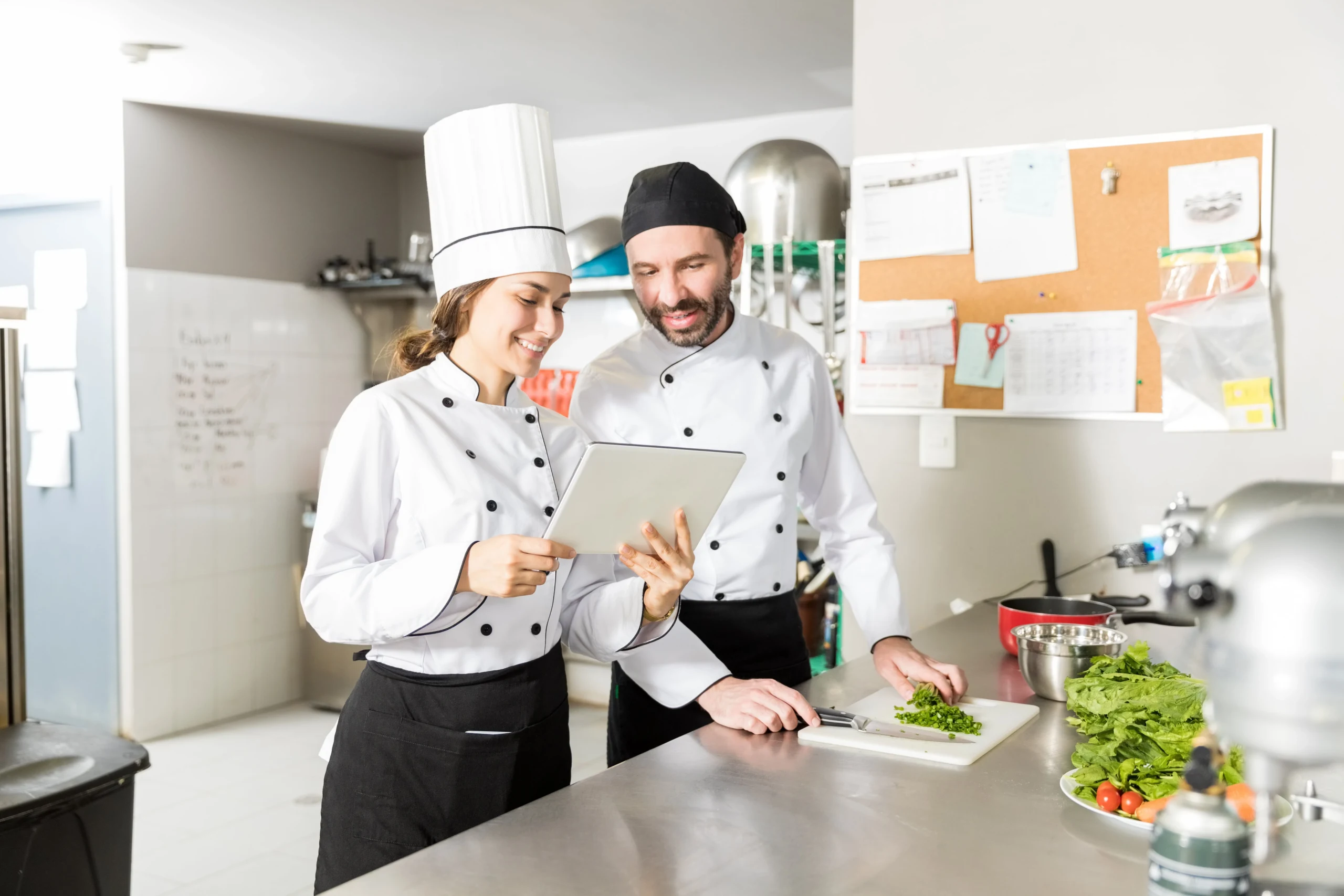 catering staff checking tablet in kitchen