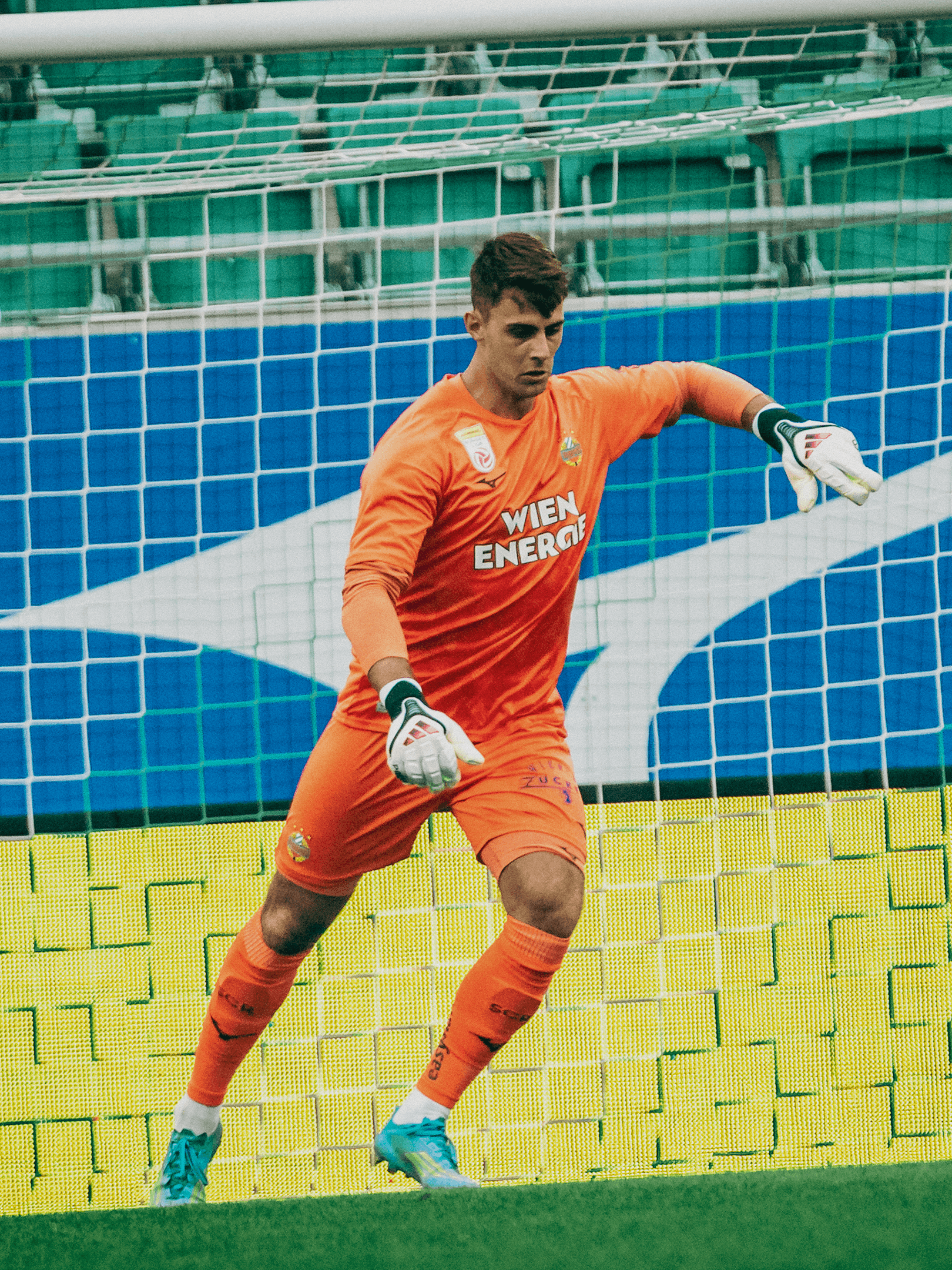 SK Rapid Torwarttrikot 26/27 in Orange im Einsatz auf dem Fußballplatz.