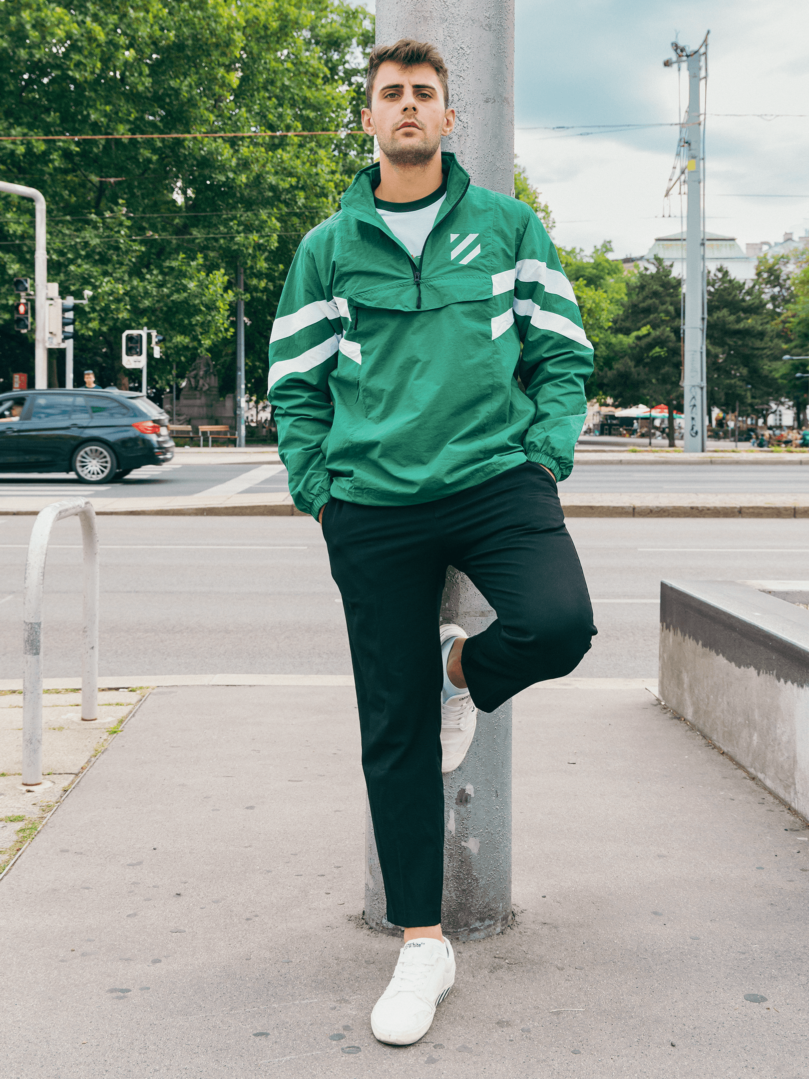 Model trägt grünen SK Rapid Windbreaker Wappenschild mit weißen Ärmelstreifen in Wien.