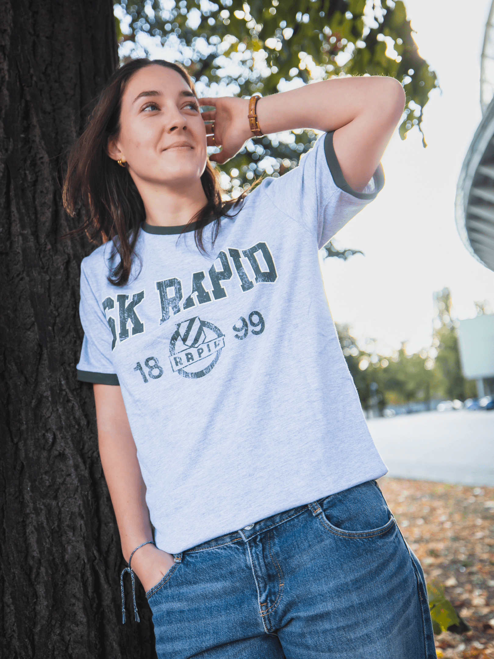 Frau trägt graues SK Rapid Vintage T-Shirt mit Retro-Print und 1899-Motiv.