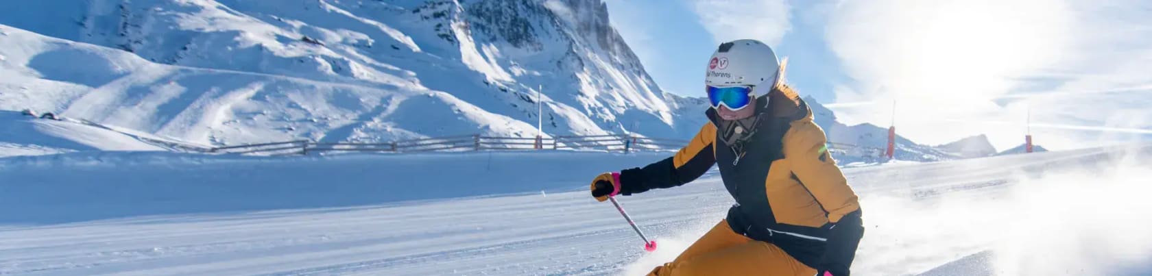 Skil�ber i orange skit�j k�rer ned af pisterne i Val Thorens