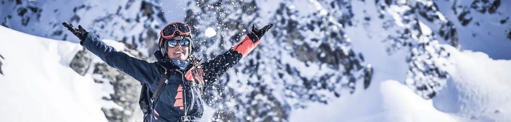 Skid�kare sl�nger upp sn� i luften med berg i bakgrunden
