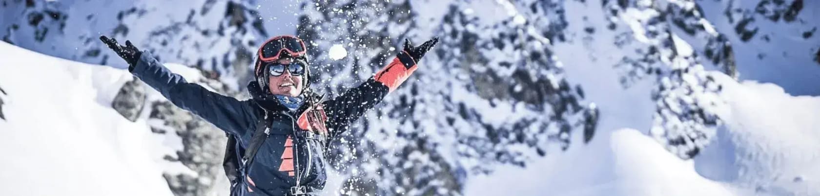 Skil�ber kaster sne op i luften med bjerge i baggrunden