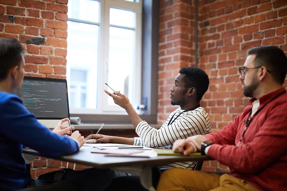 Photo of a group of engineers discussing code