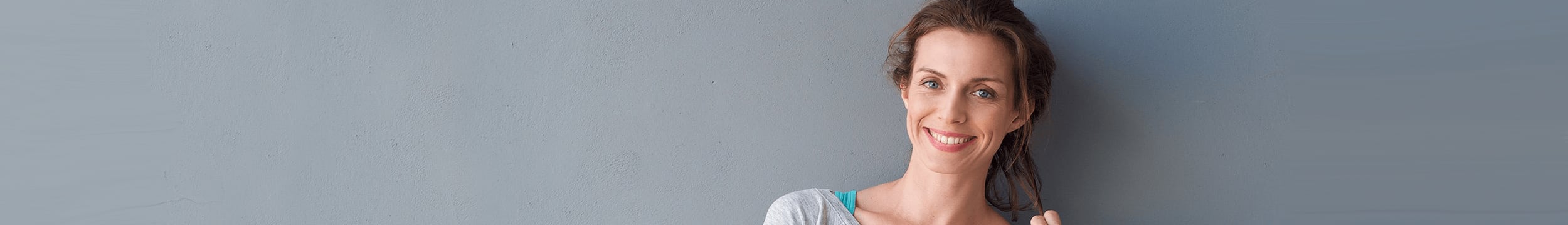 older woman with blonde hair leaning on arm on white background