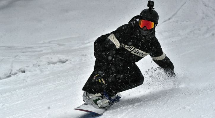 Snowboarder wearing a neck gaiter over mouth and neck during winter