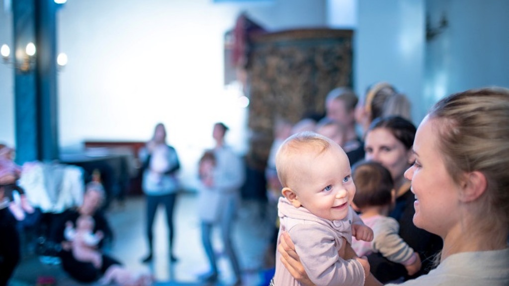 Foresatt holder et smilende barn på babysang