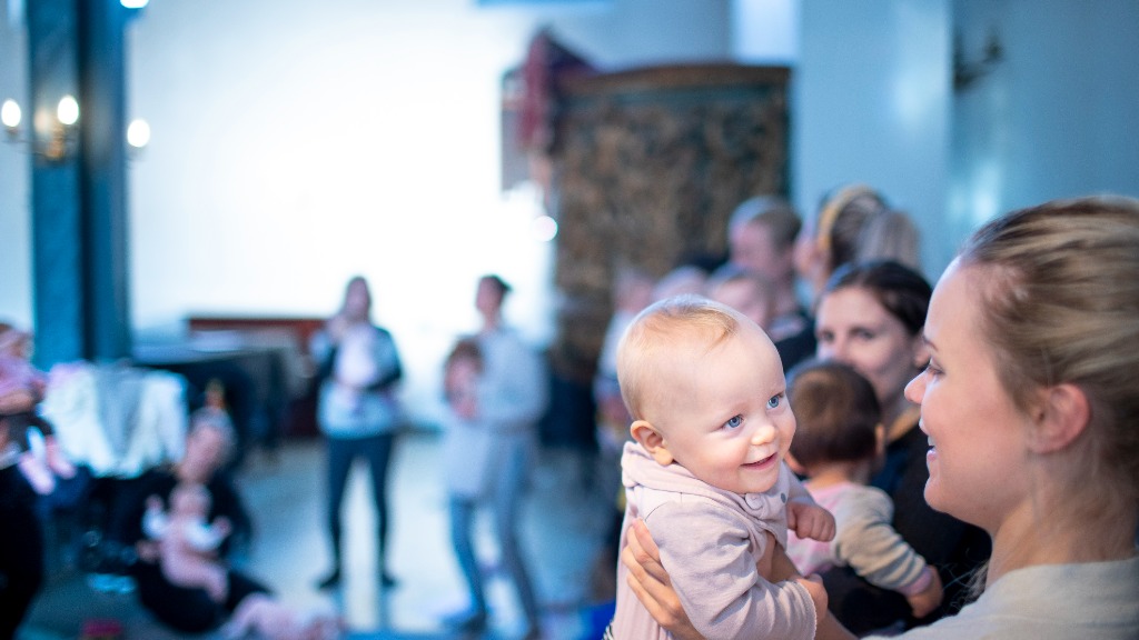 Smilende baby sammen med mamma
