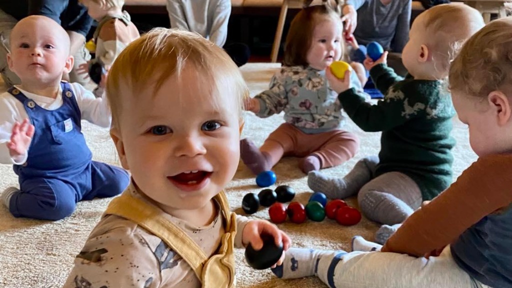 Baby som smiler, babyer som leker med rasleegg
