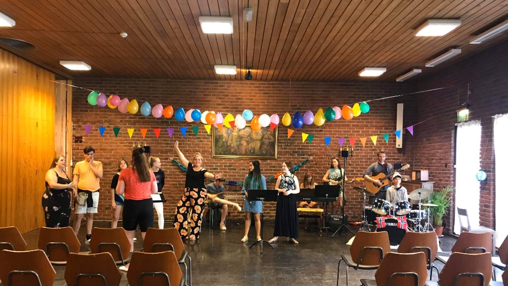 Ungdom som spiller i band og danser under fargerike vimpler og ballonger