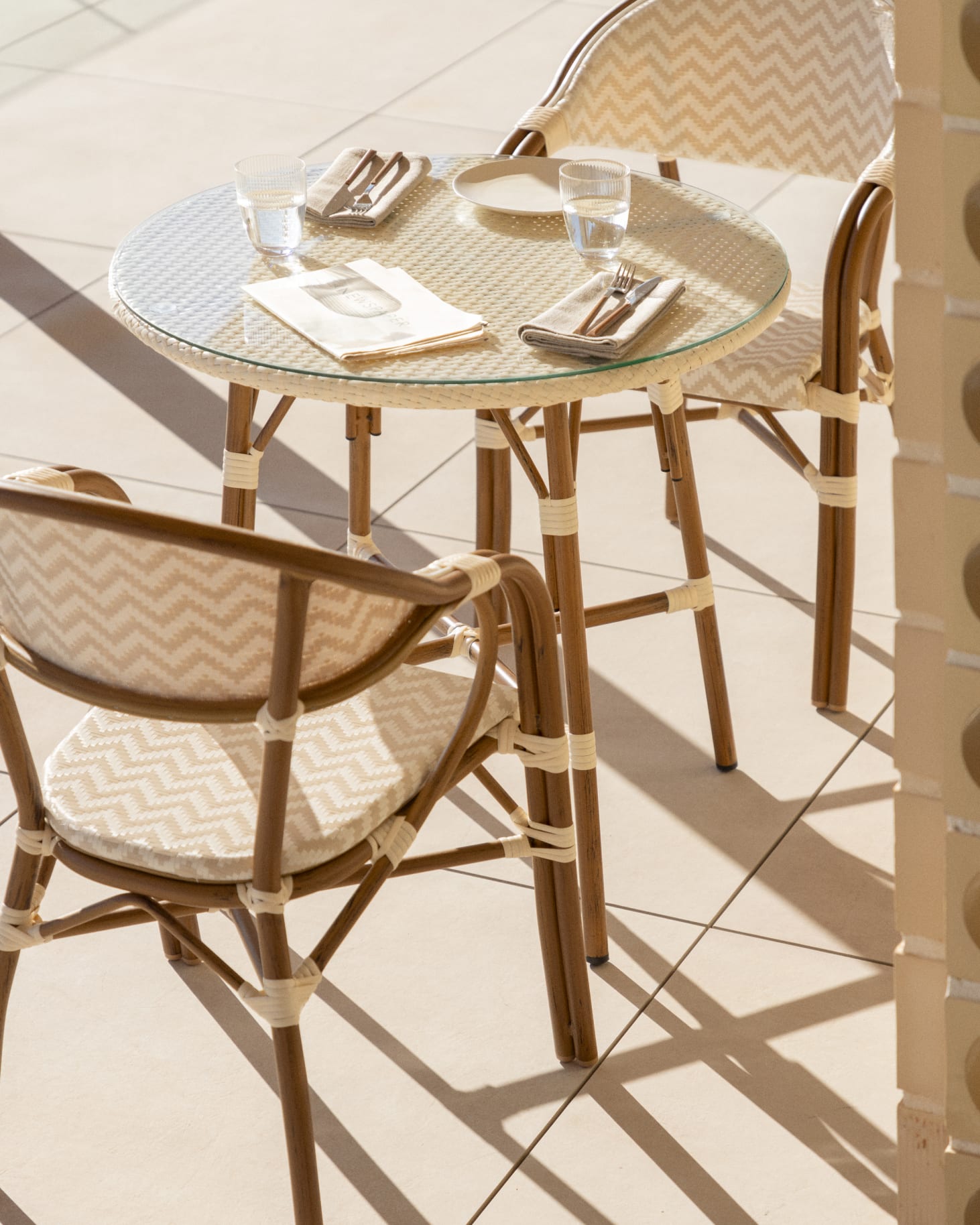 Brielle Bistro round table set, Ø80 cm, and two stackable dining chairs with armrests in aluminium.