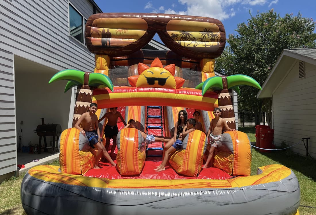 Kids having fun on a Sky High Party Rentals tropical water slide