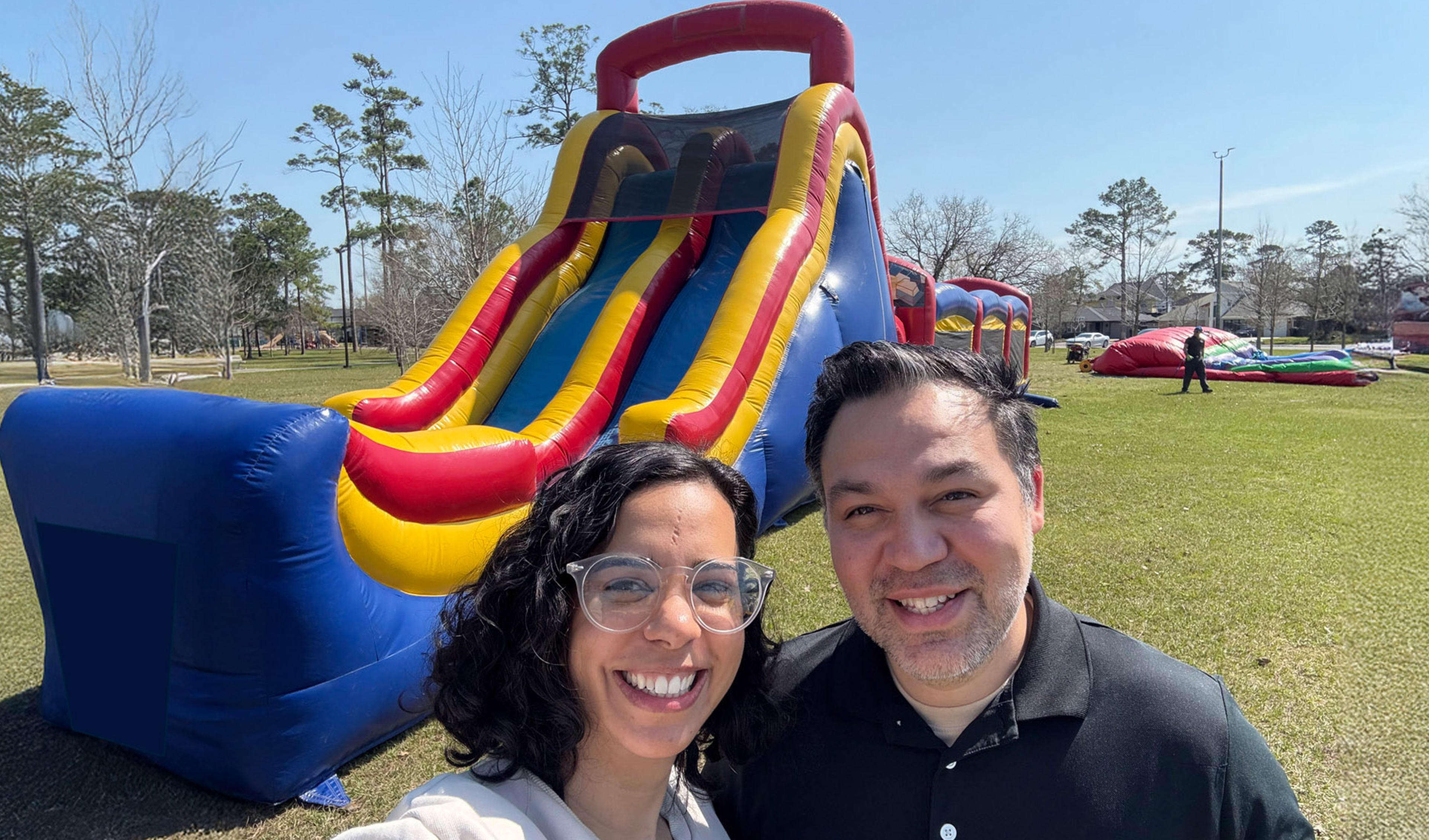 Owners of Sky High Party Rentals standing in front of 60ft Obstacle