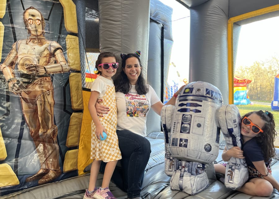 Maria De Los Santos with daughters Susy and Veronica in a Star Wars bounce house