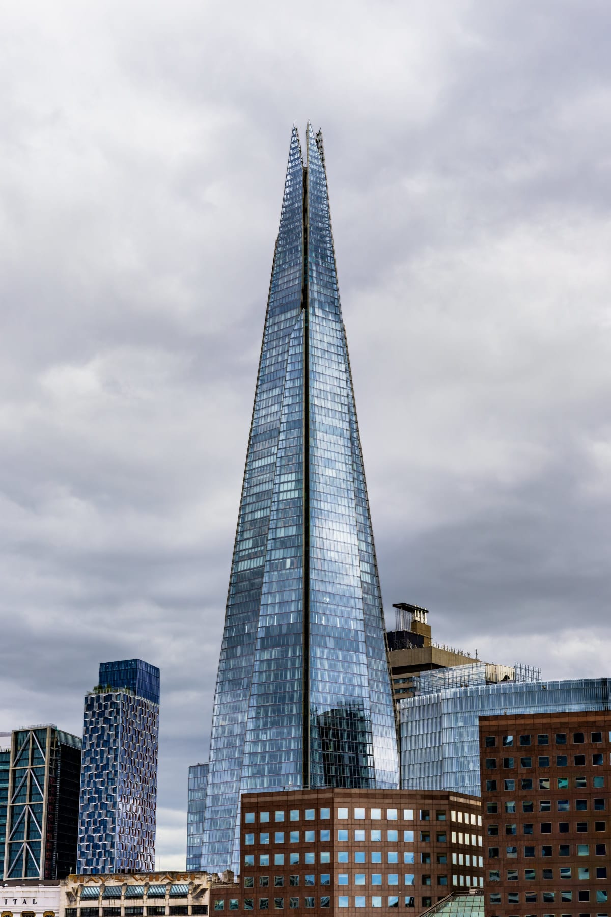 The Shard rising above London's skyline beneath a dramatic overcast sky