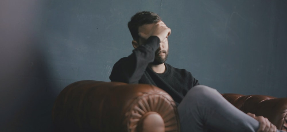 man sitting down with his head in his hands