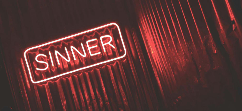 neon sign that reads "sinner"