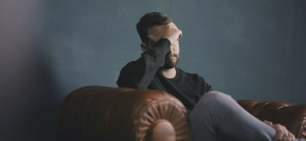 man sitting down with his head in his hands