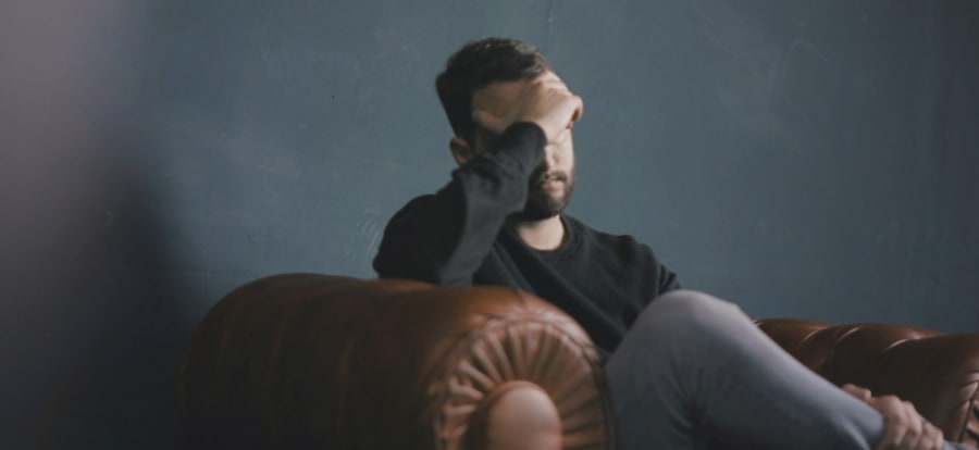 man sitting down with his head in his hands