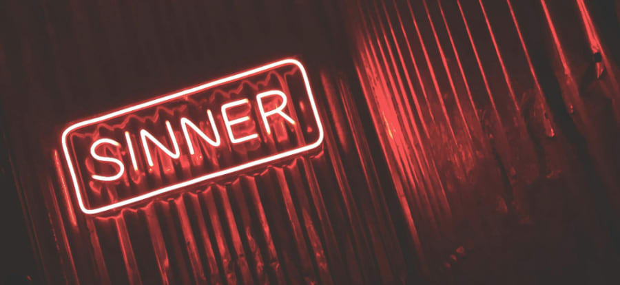 neon sign that reads "sinner"