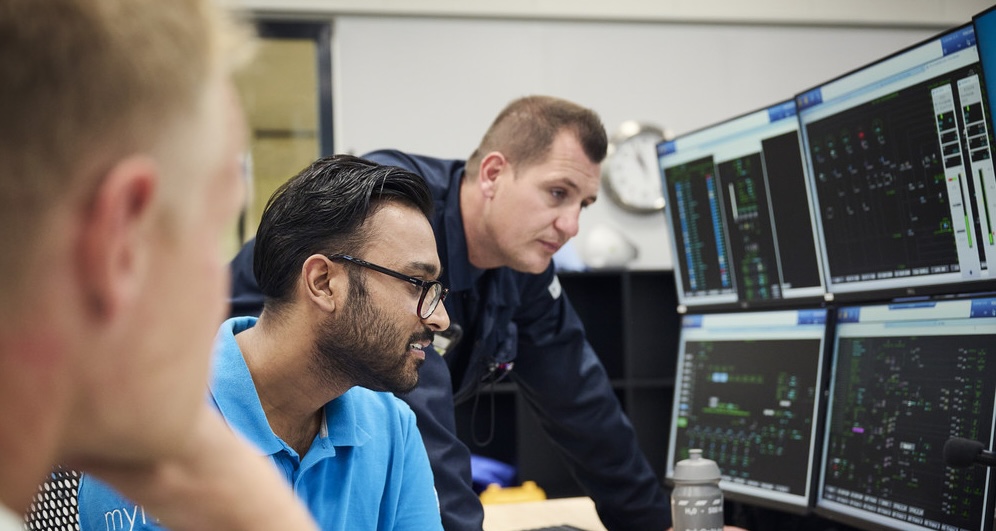 Two men talking indoors.