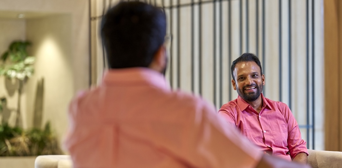 Two men talking indoors.