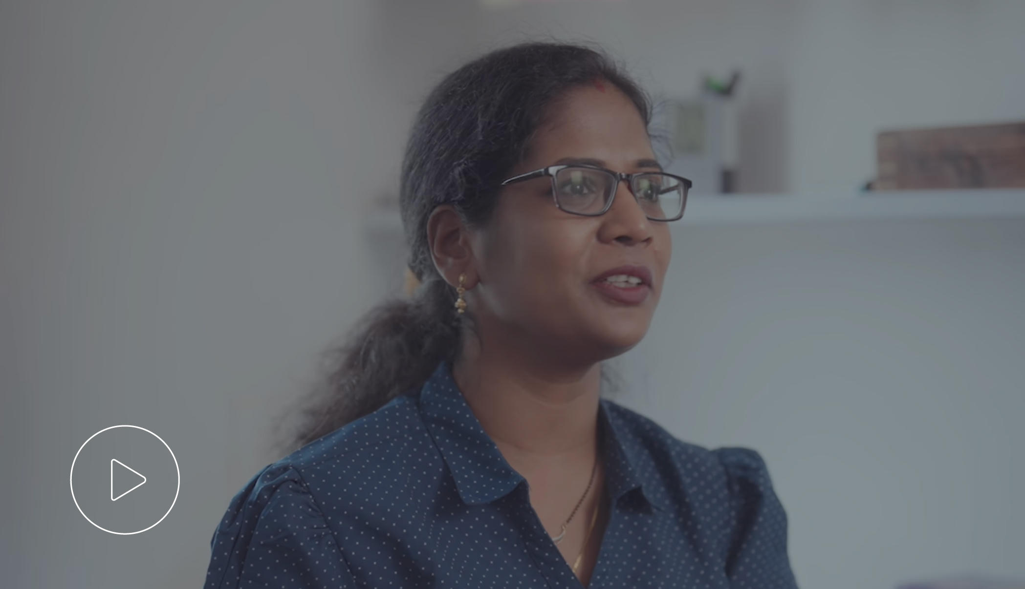 Woman smiling confidently in a professional setting.