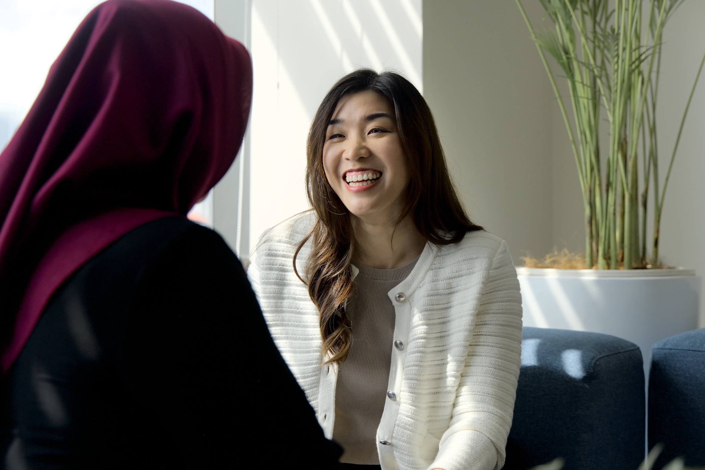 employees speaking at a table smiling.
