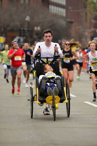 Runner helping a participant with a disability during a marathon race.