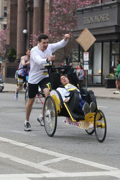 Runner helping a participant with a disability during a marathon race.