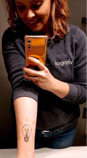 woman taking a selfie photo with her tatoo