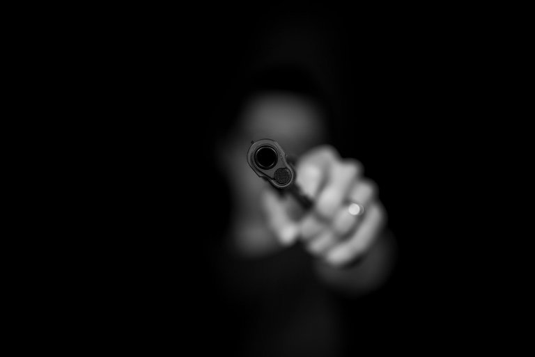 Persona apuntando una pistola.