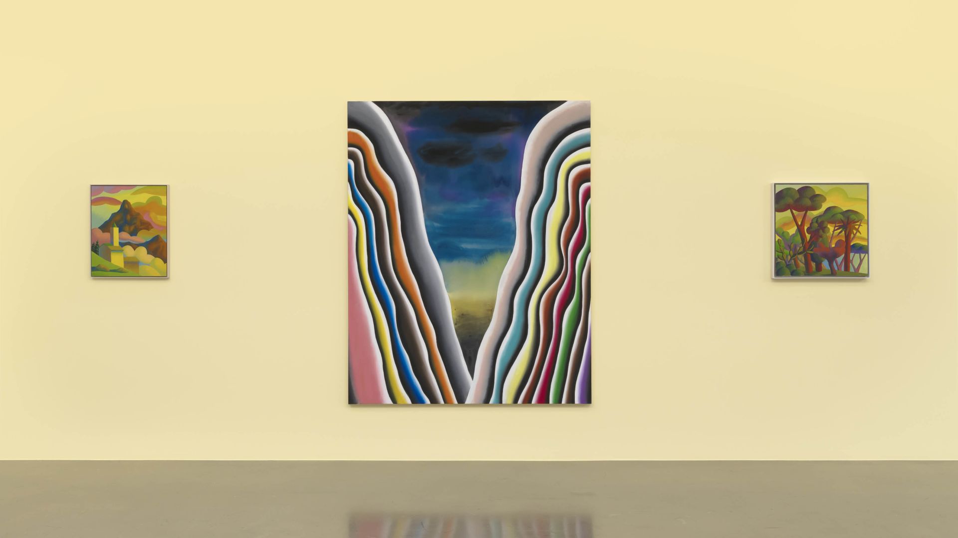 Gallery wall displaying the same colorful abstract V-shaped painting as the centerpiece, with two smaller landscape paintings positioned on either side